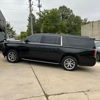 A black suv is parked in a parking lot next to a building.