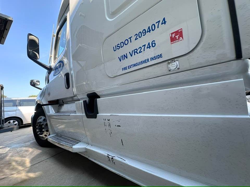 A white truck with dent and scratch.