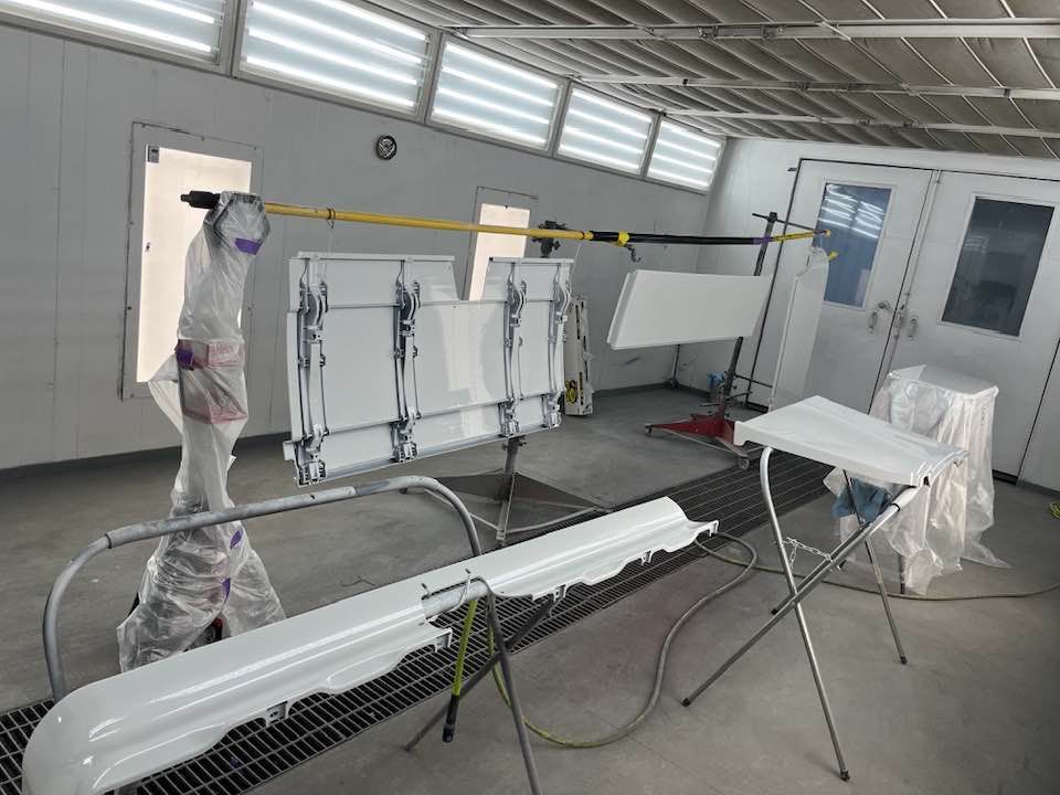 A person is painting a piece of furniture in a paint booth.