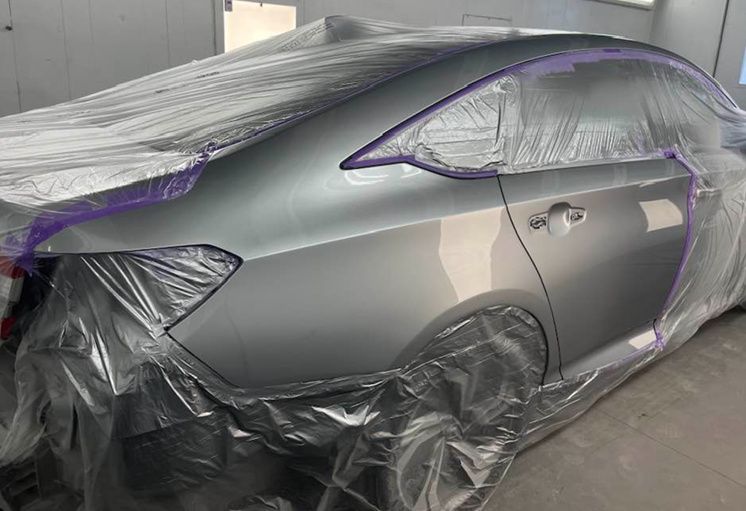 A car is wrapped in plastic and ready to be painted.