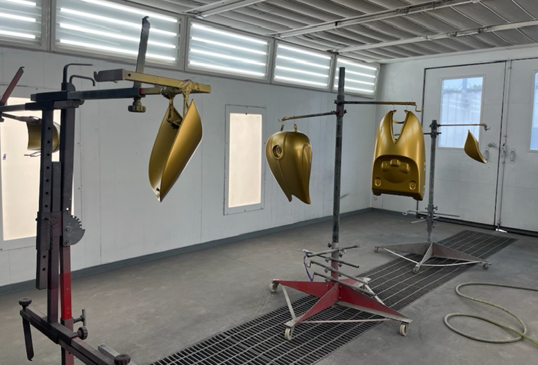 A car is being painted in a paint booth.