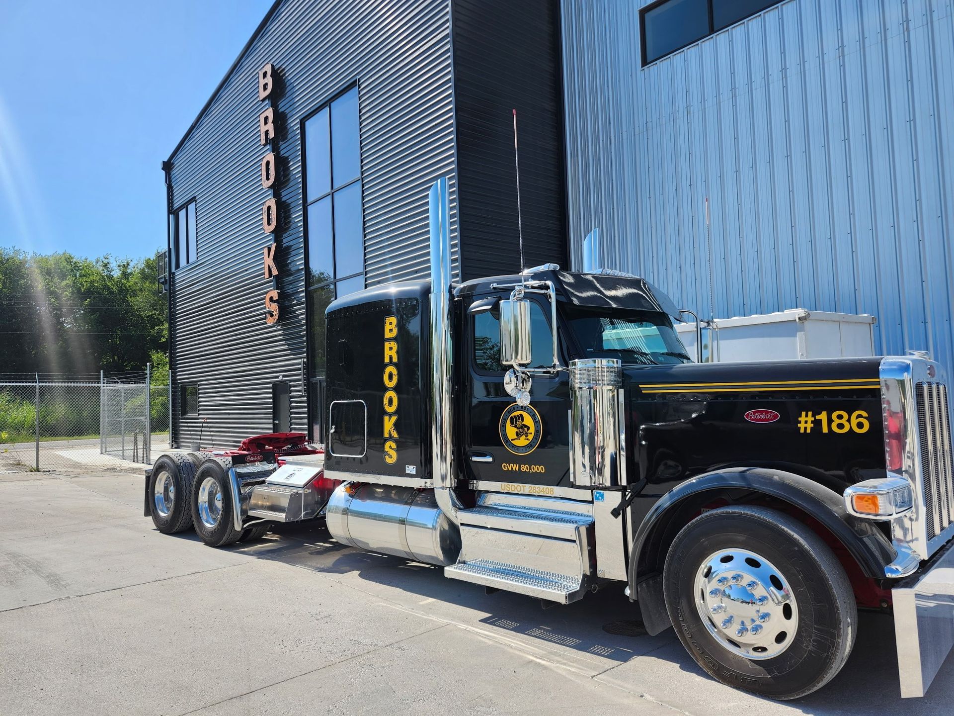 Black semi-truck parked in front of a building with the name 