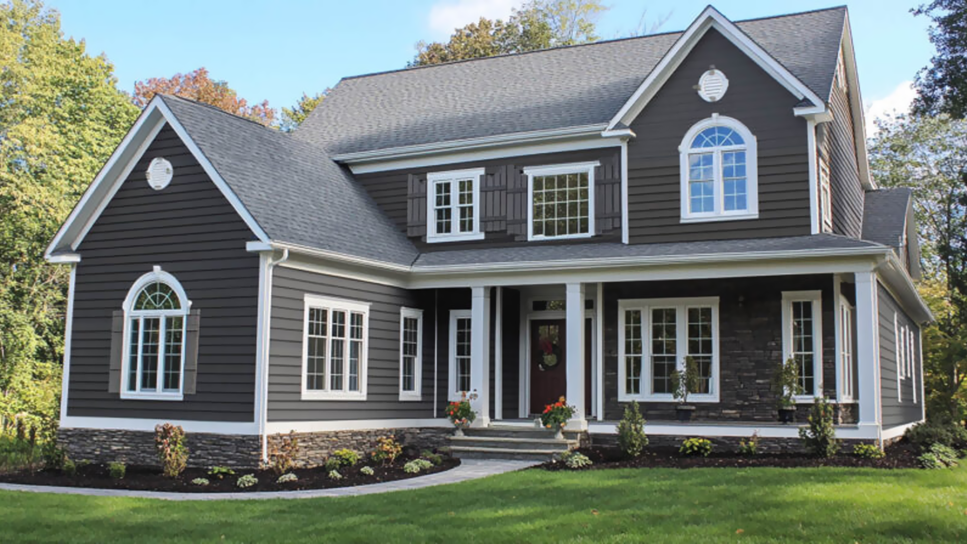 Learn more about Siding A white house with a black roof and a white gutter.