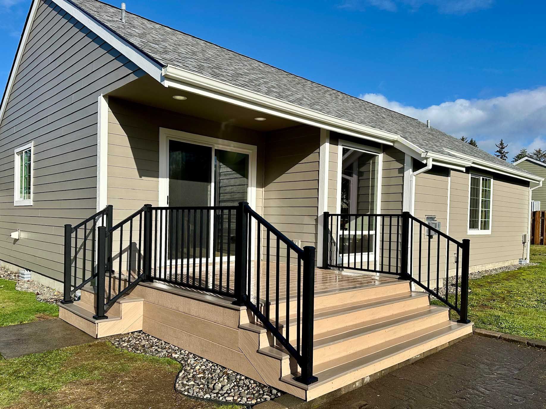 A small house with stairs leading up to the front door.