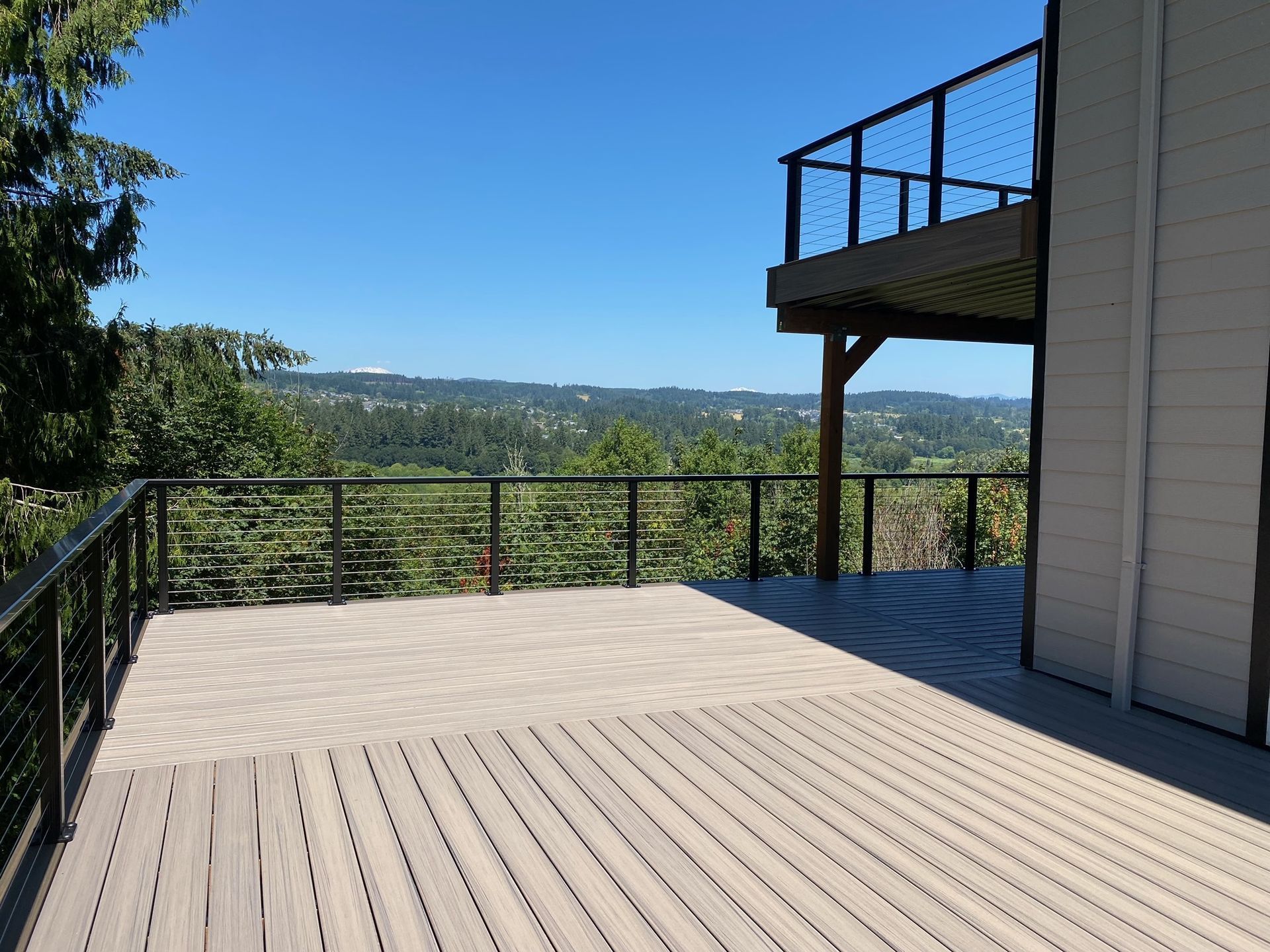 A large deck with a view of the mountains and trees.
