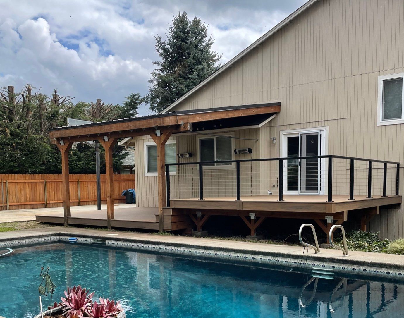 A house with a deck and a swimming pool in front of it