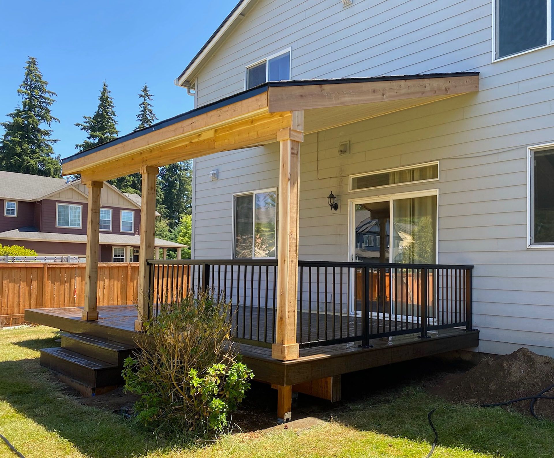 A white house with a wooden deck in front of it.