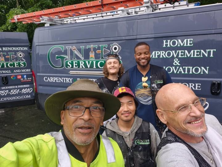 Five smiling workers posing in front of a Gintro Services home improvement van