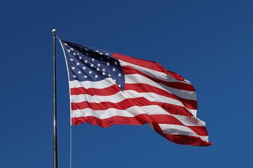 American flag waving on a pole against a clear blue sky