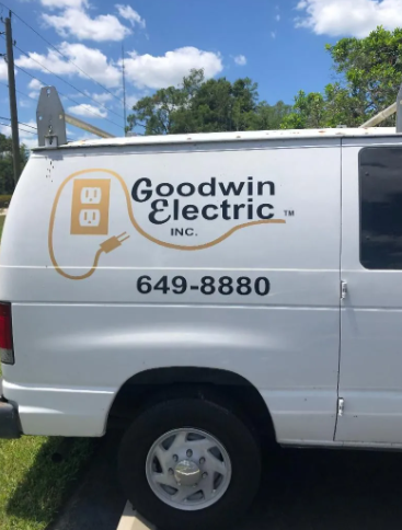 White Goodwin Electric van parked outdoors with logo and phone number 649-8880 on the side