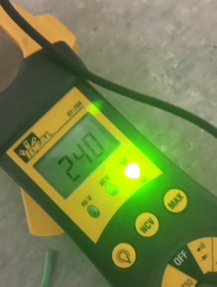 Yellow handheld digital meter showing 24.0 on a green backlit screen