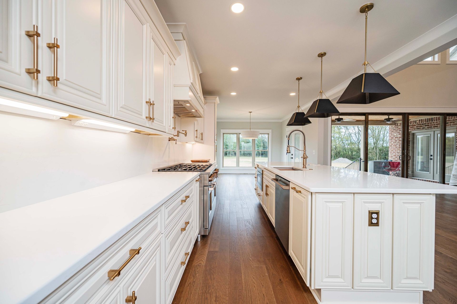Bright, modern kitchen with white cabinets, gold hardware, and a large island.