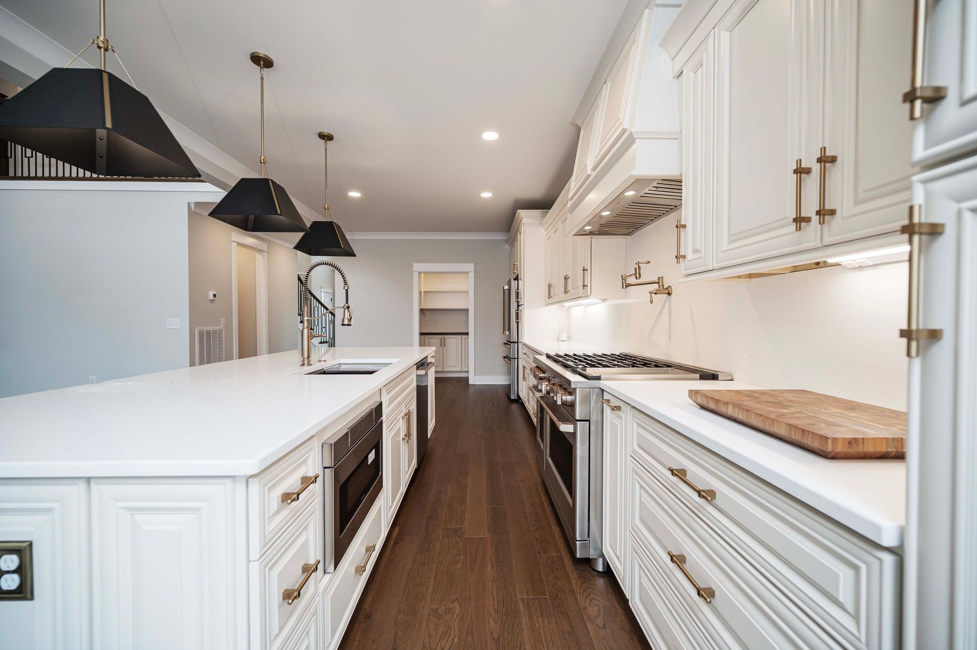Modern kitchen with white cabinets, island, and dark wood floors.