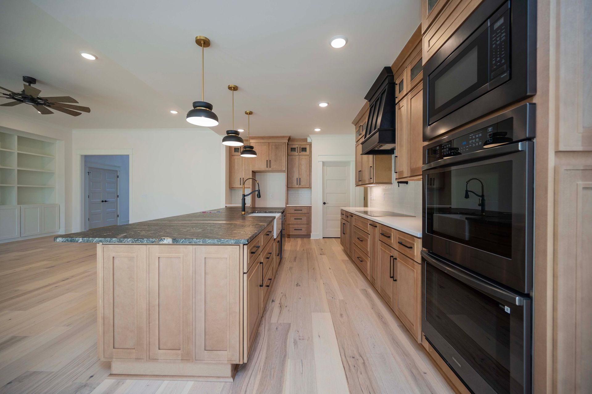 Spacious kitchen with wood cabinets, island, and black appliances.