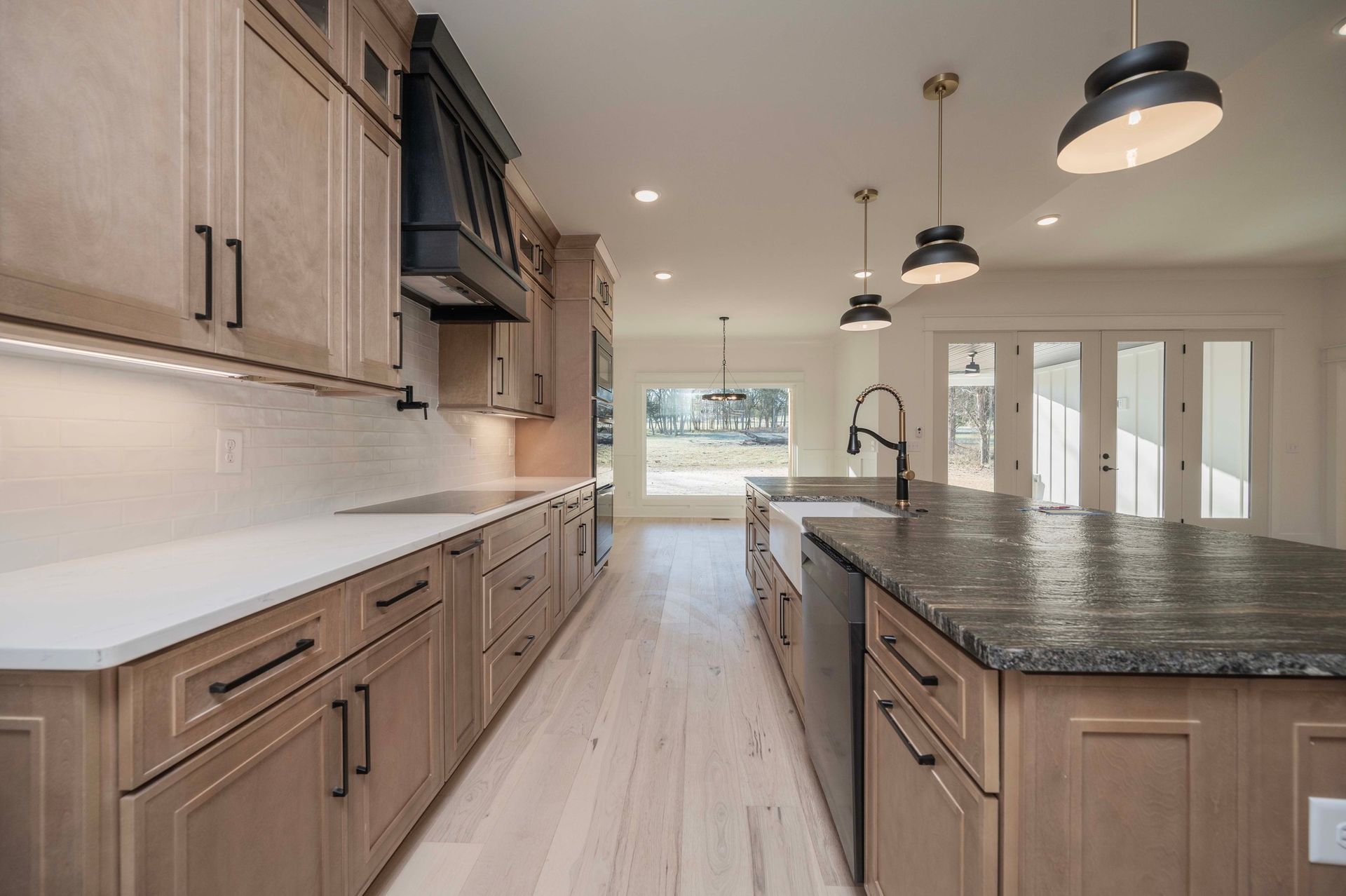 Spacious kitchen with wood cabinets, white countertops, and a large island with a dark countertop.
