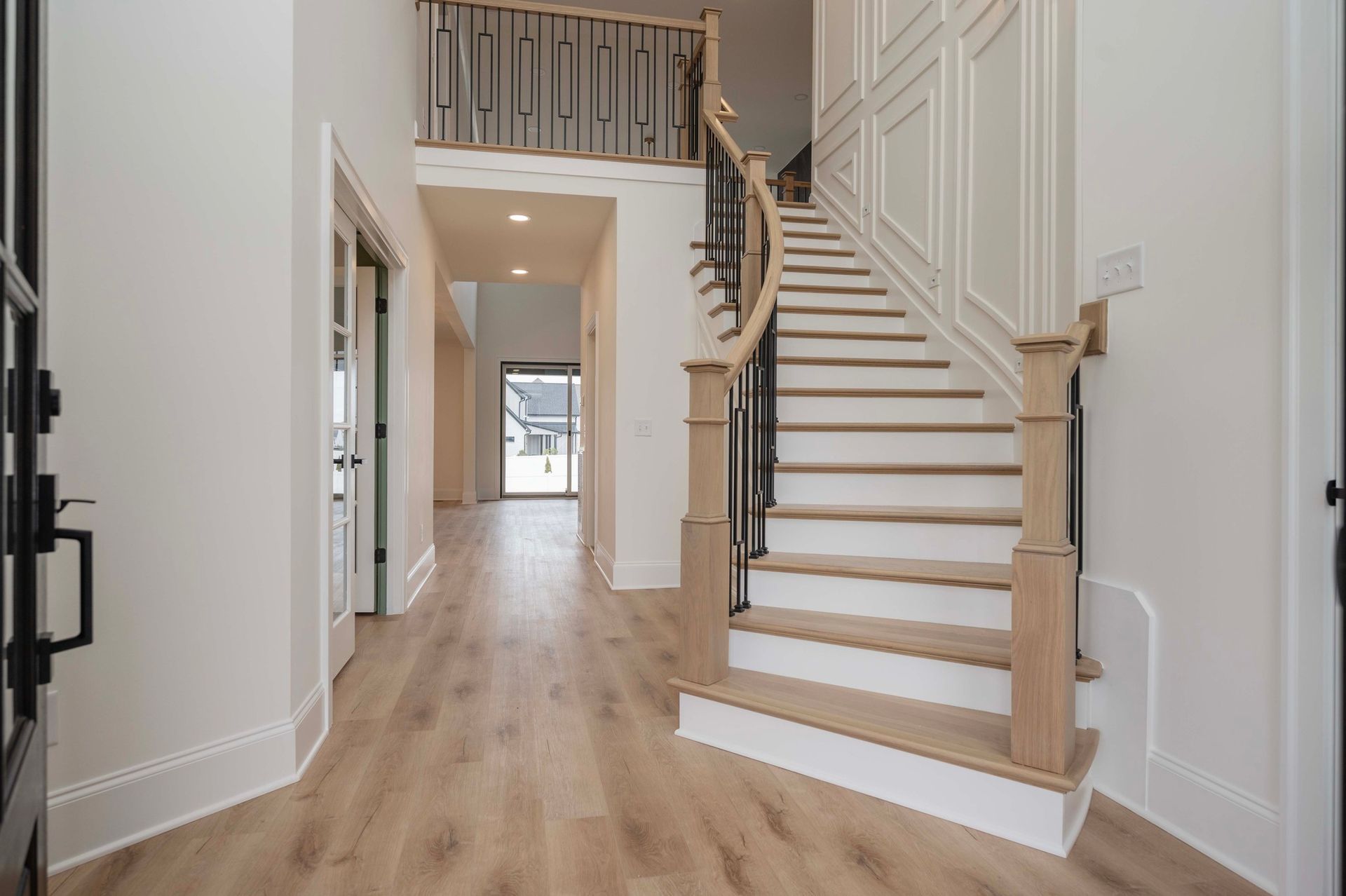 Interior of a home with a wooden staircase and light-colored flooring.