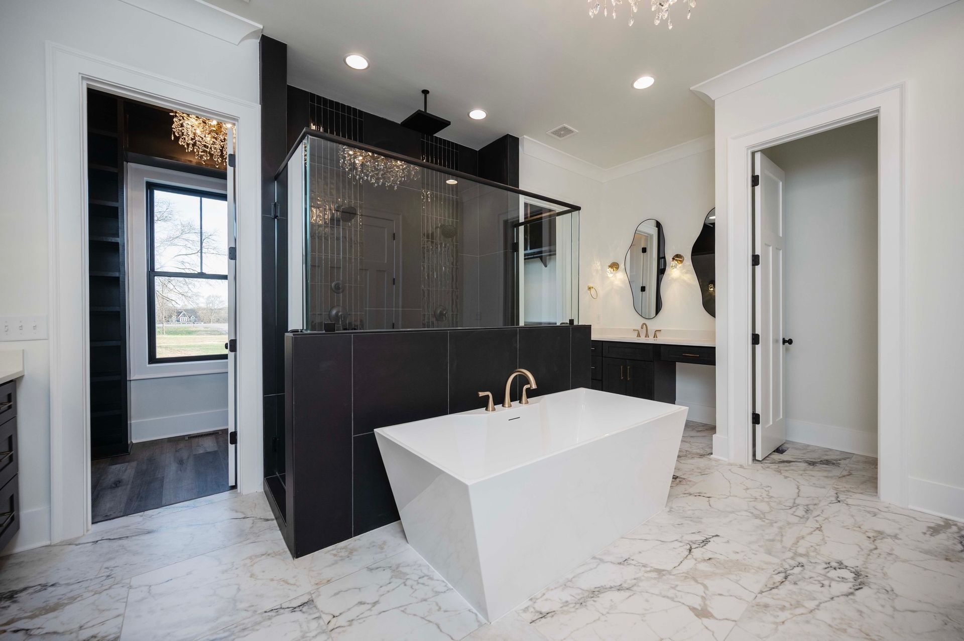 Luxurious white bathroom with a black accent shower, tub, and vanity.
