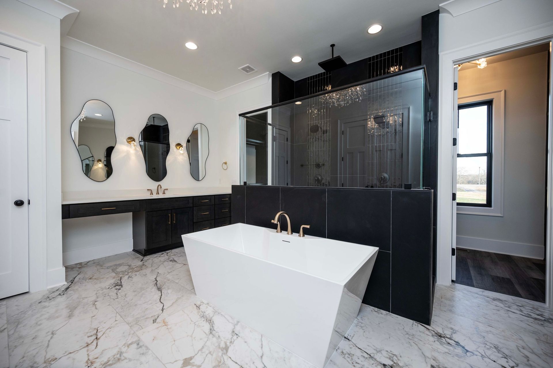 Modern bathroom with a white tub, dark cabinets, and marble flooring.