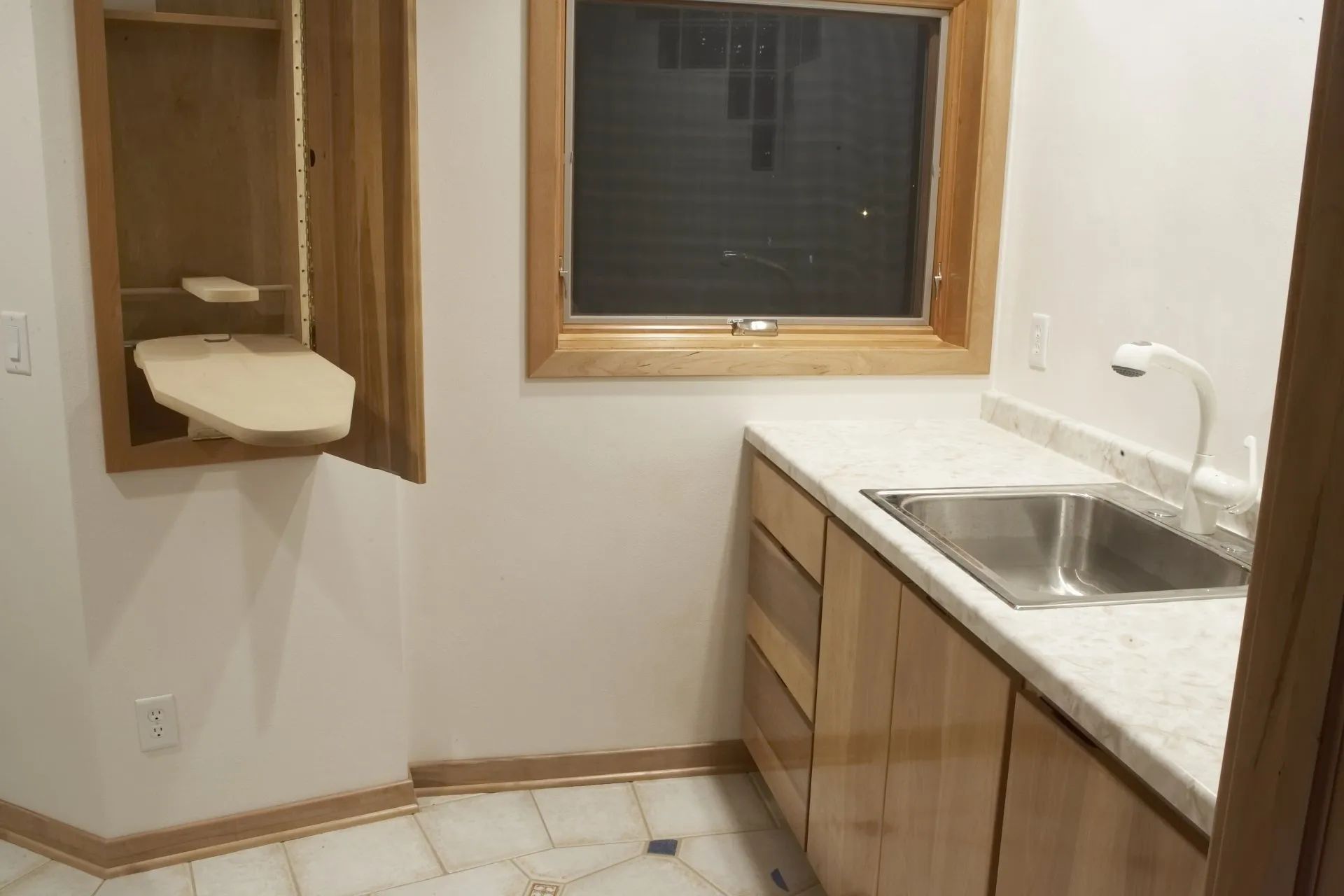 Small bathroom with a sink, mirror, window, and a wall-mounted changing table.