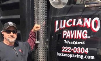 A man is standing in front of a truck that says  Luciano Paving