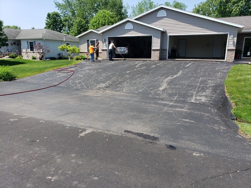 A car is parked in a driveway in front of a house.