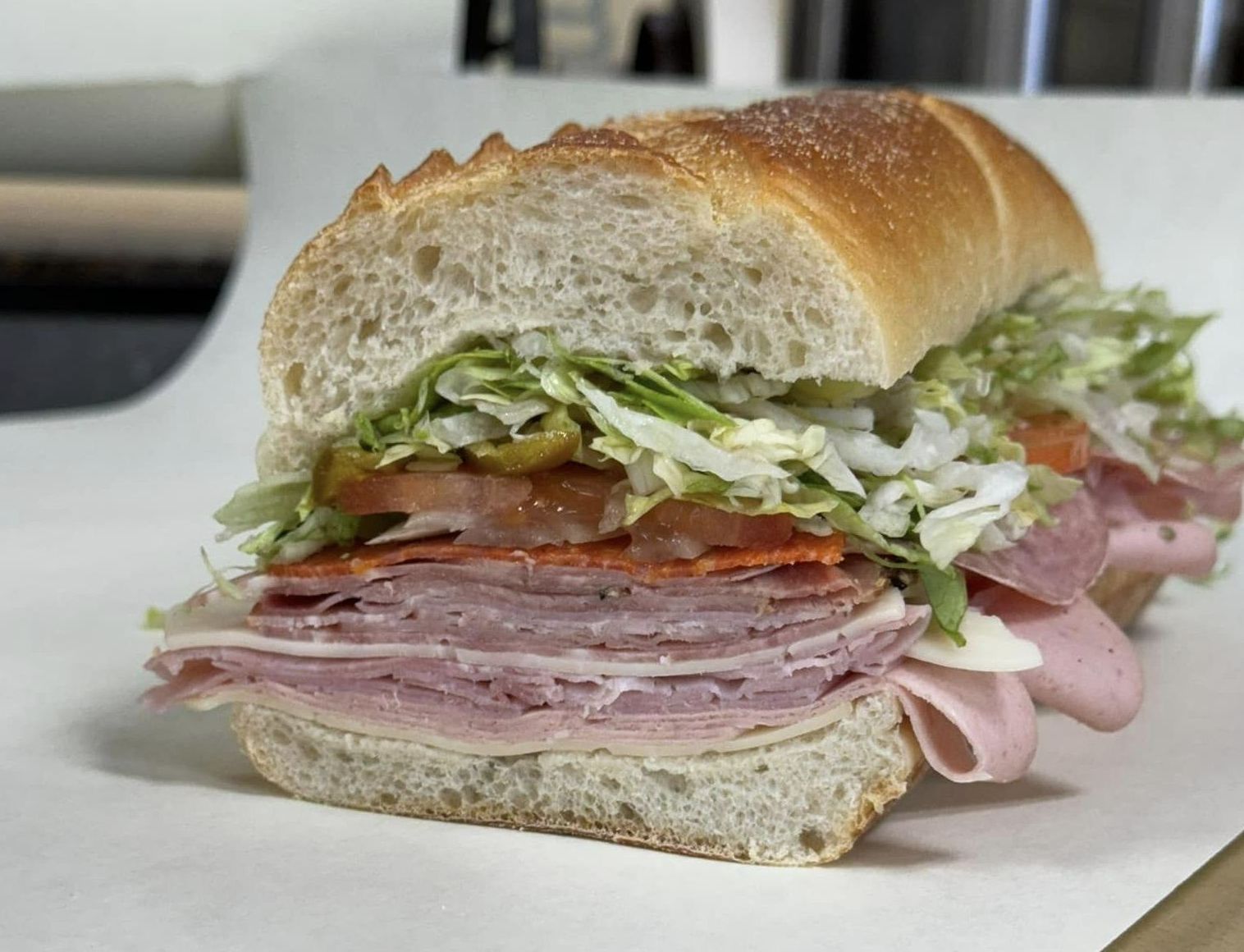 A sub sandwich is cut in half and sitting on a table.