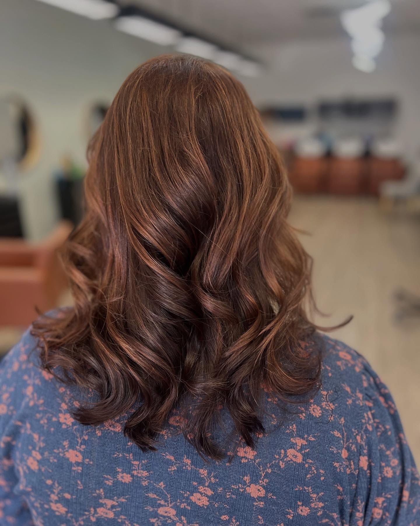Woman with brown, wavy hair and subtle highlights.