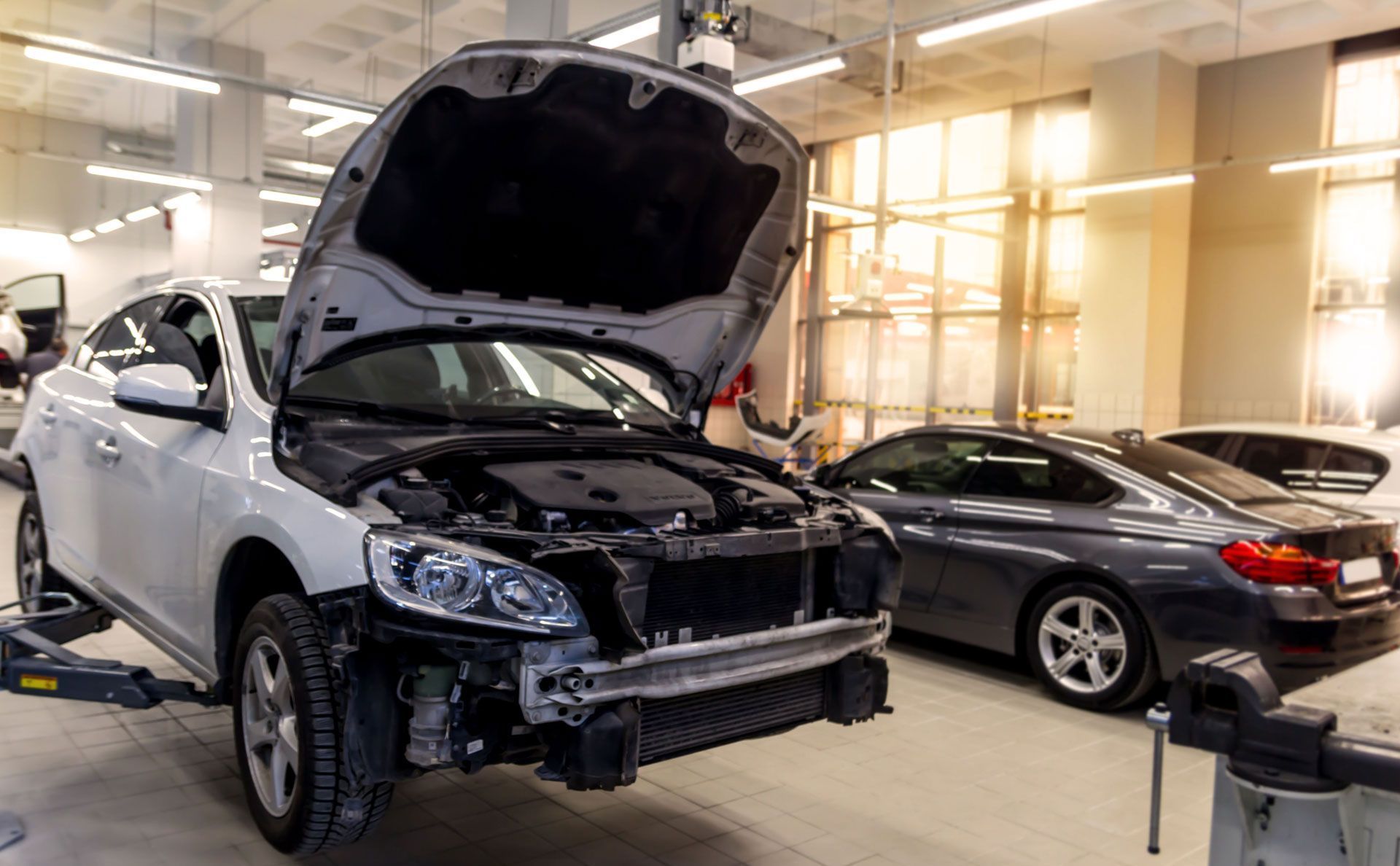 A man wearing blue gloves is polishing a car with a machine.