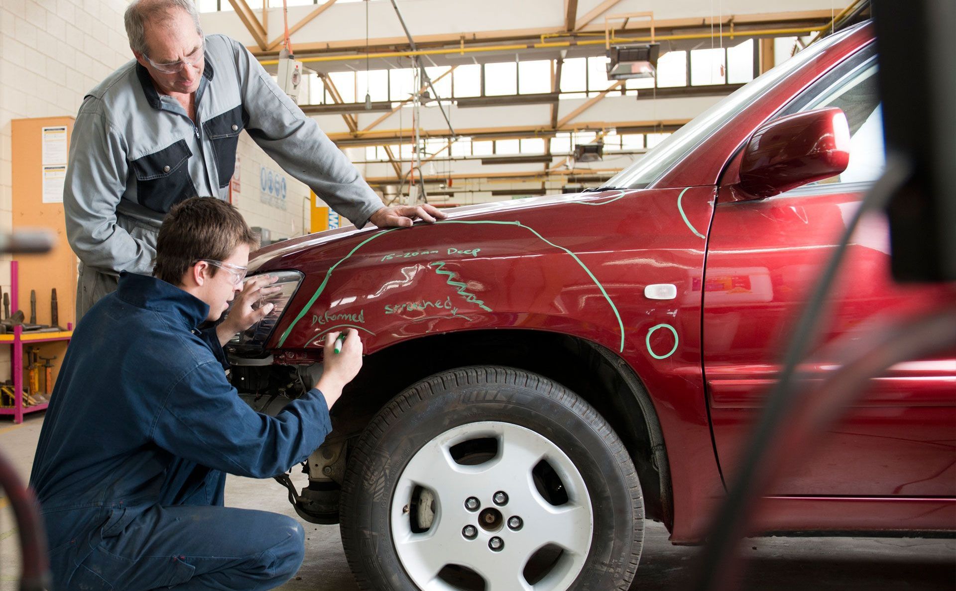 A close up of a white car with a damaged bumper.