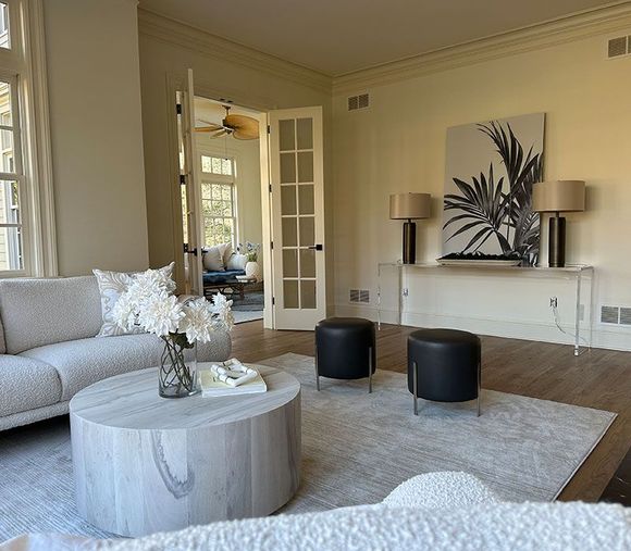 A living room with a white couch and a round coffee table