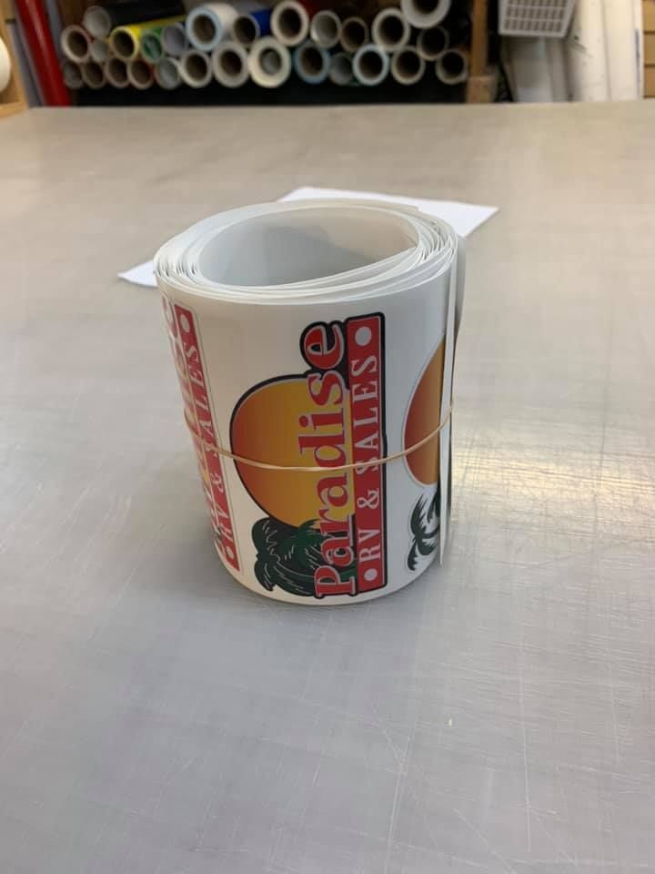 Rolled decal with orange and red design on a worktable in a workshop