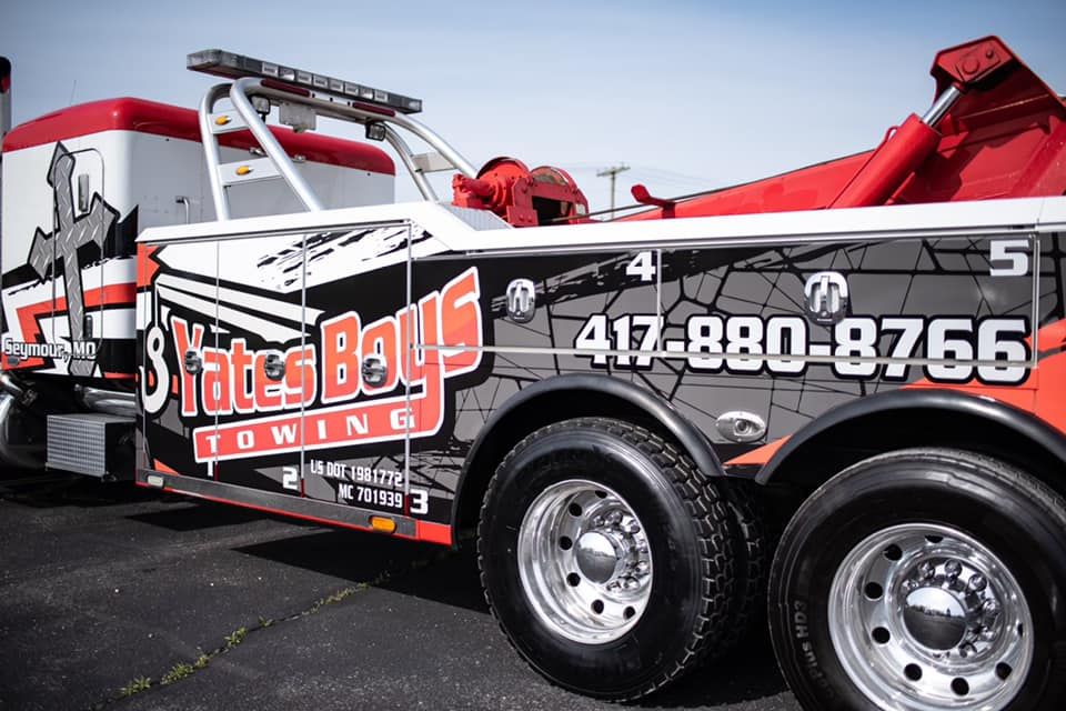 Red State Boys Towing truck with red wrecker arm and phone number on the side