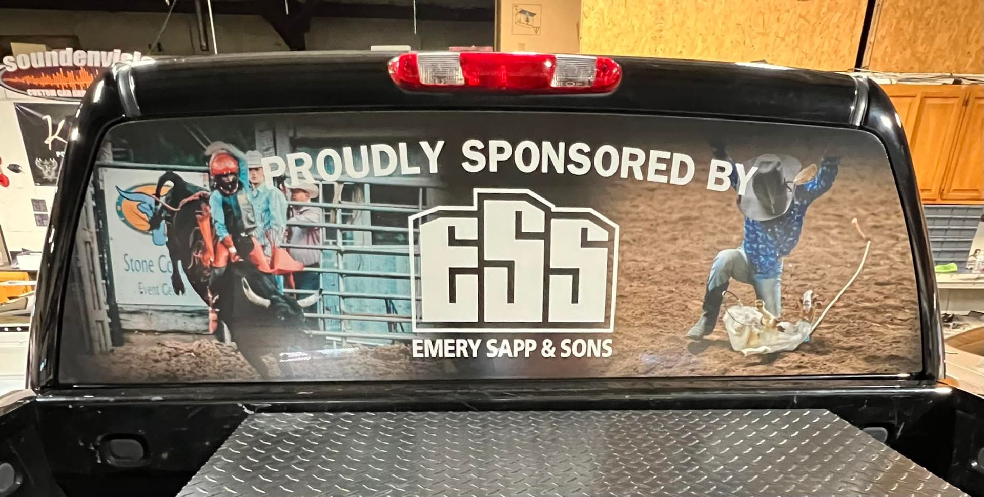 Truck rear window decal reading “Proudly Sponsored by Emory’s B&P & Sons,” with fishing graphics and logo