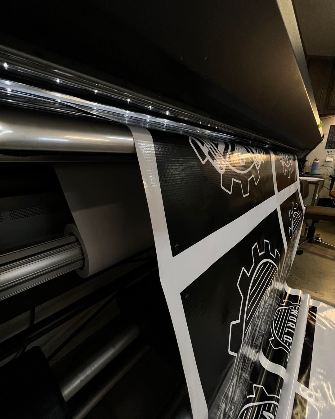 Large-format printer producing black-and-white posters in a print shop
