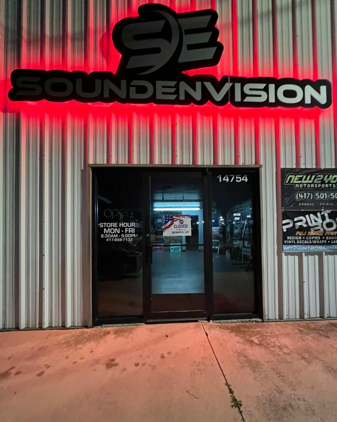 Soundenvision storefront with red neon sign and glass entrance at night