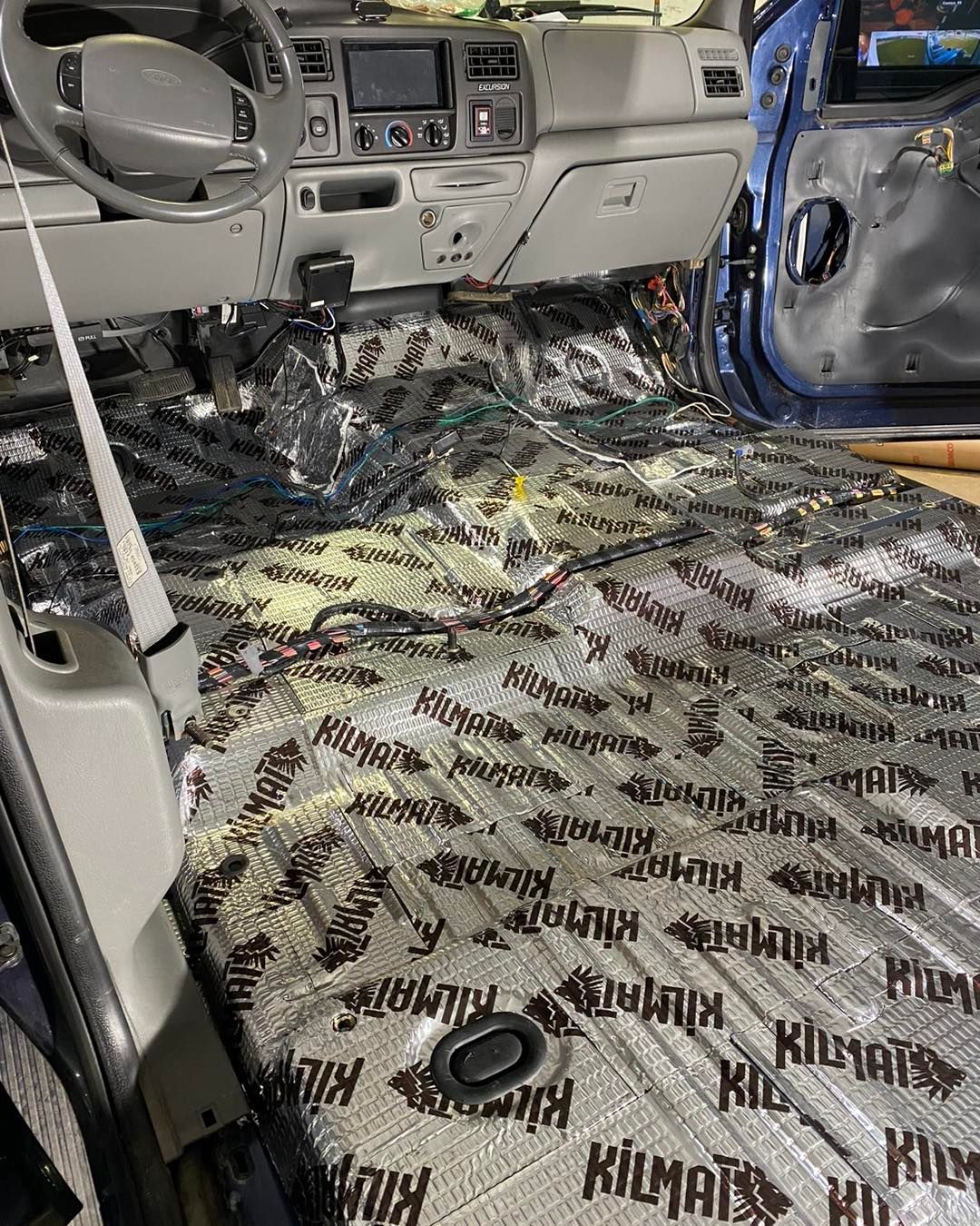 Damaged car interior with deployed airbags and debris scattered across the floor.