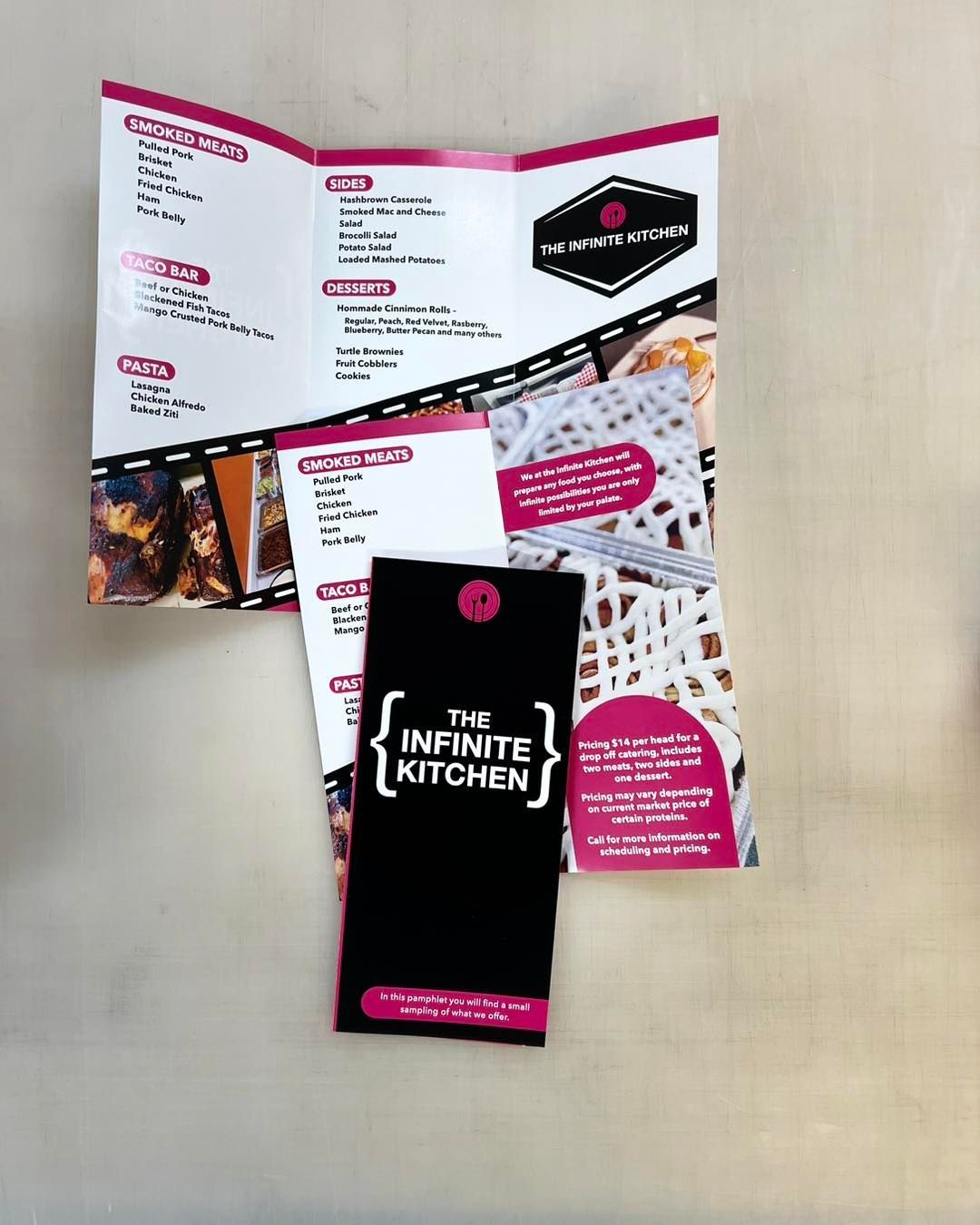 Open brochure and black smartphone-shaped flyer on a beige surface
