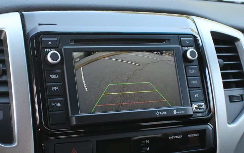 Car dashboard with a built-in touchscreen showing the rearview camera backup view