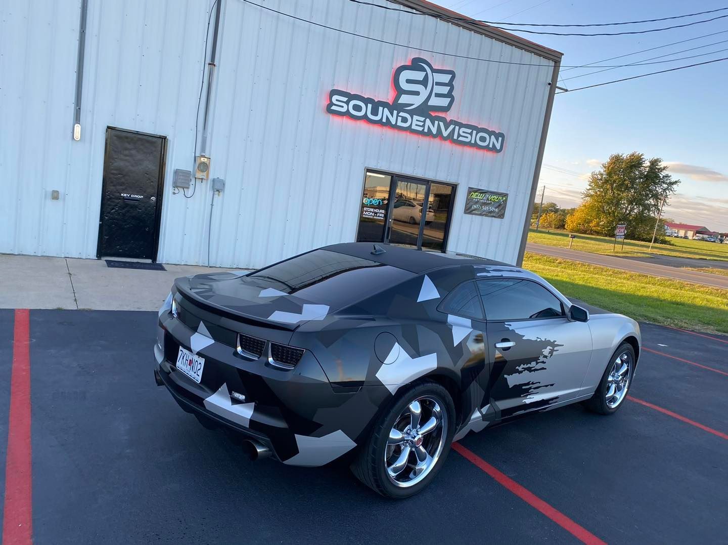 Black sports car parked beside a building with a Souvenirs sign.