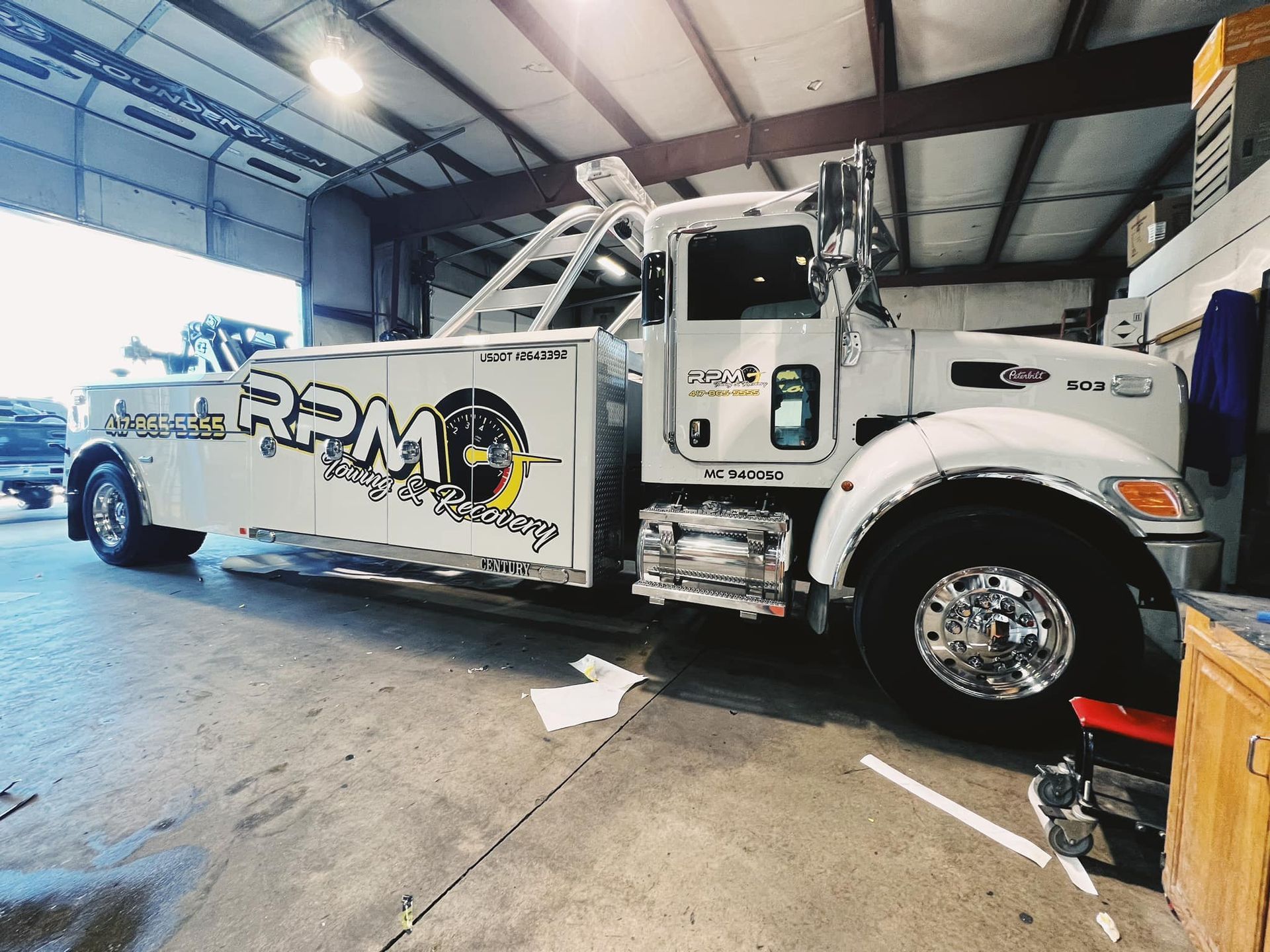 Tow truck with RPM graphics parked inside a warehouse garage