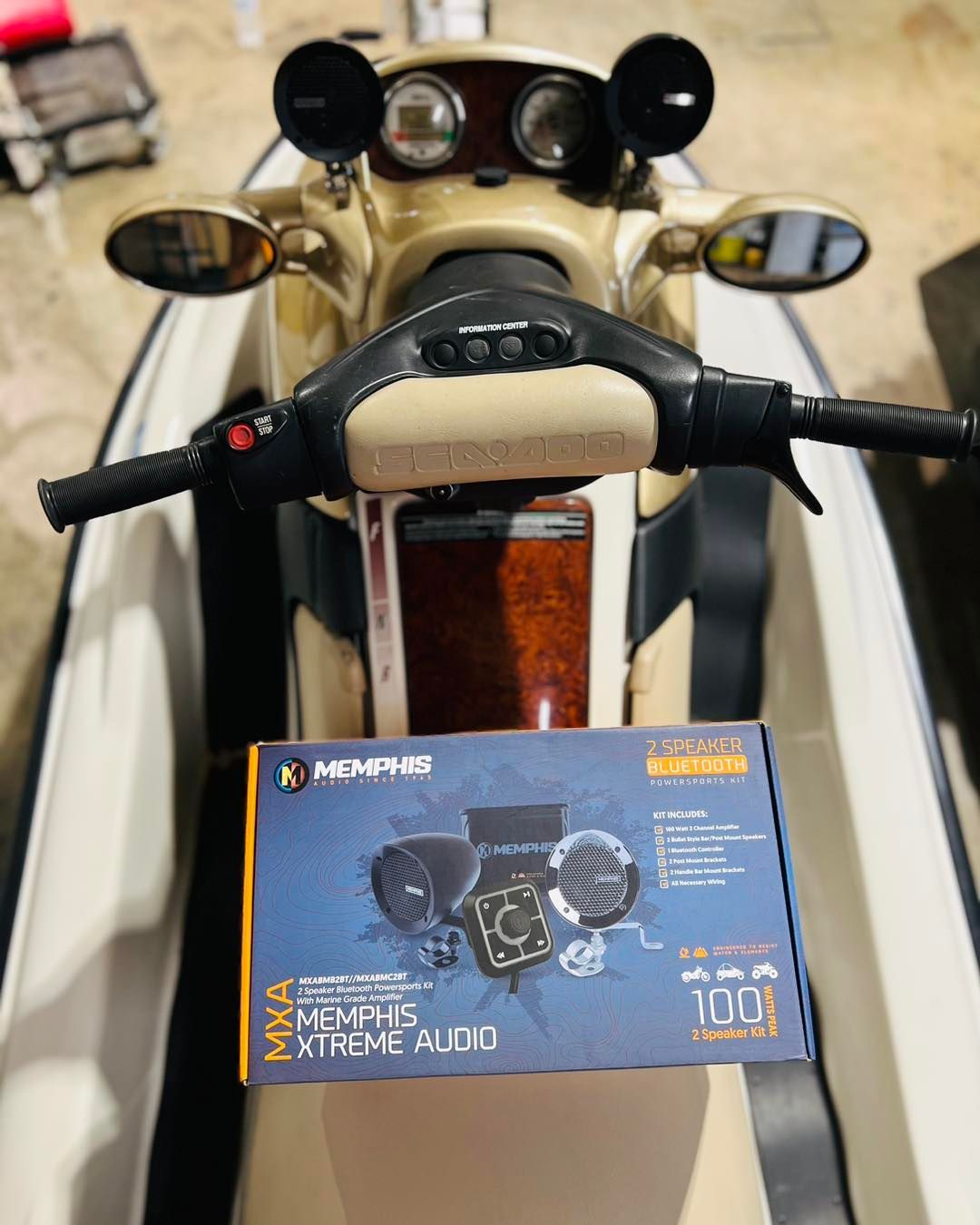 Motorcycle dashboard with a blue Mars Motorsports Extreme Audio box on the seat, seen from above