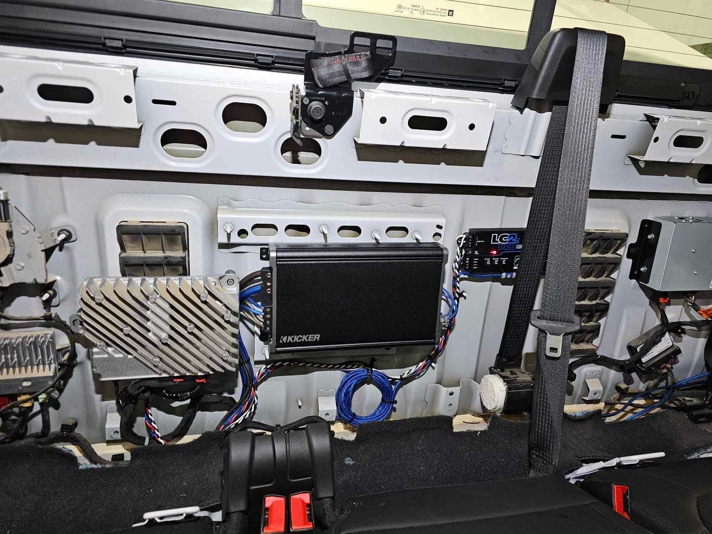 Open car door interior with exposed panels, wiring, and mounted electronics.