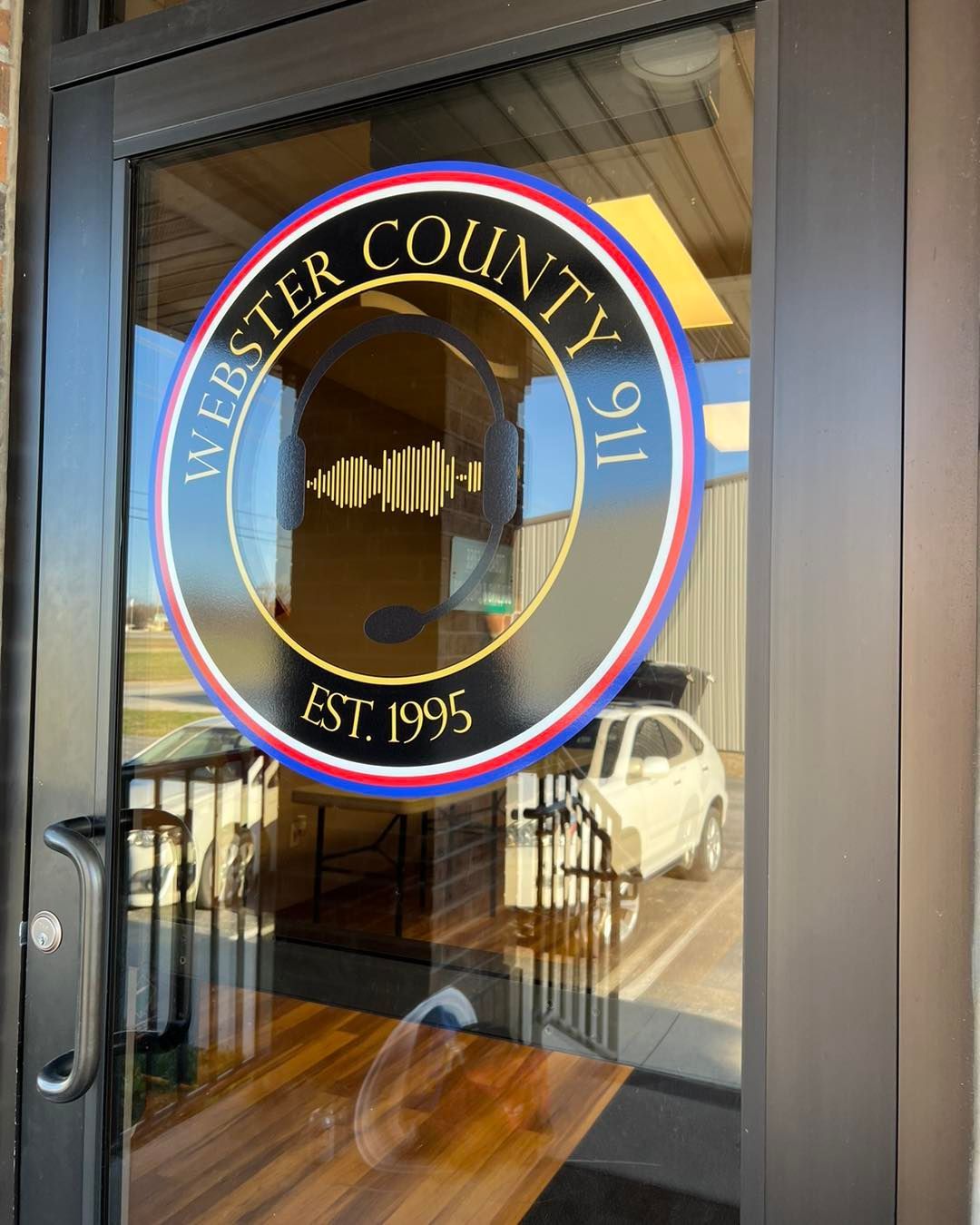 Westchester County seal on a glass door, with reflections and a metal-framed entrance behind it.