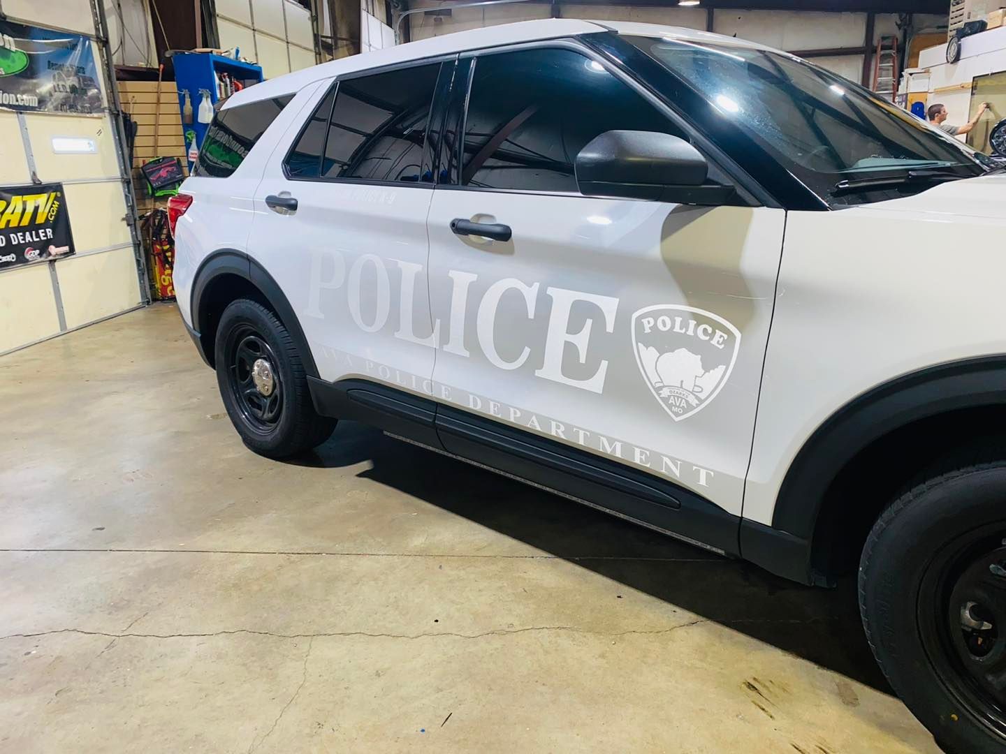 White police SUV with large “POLICE” lettering parked in a garage or workshop