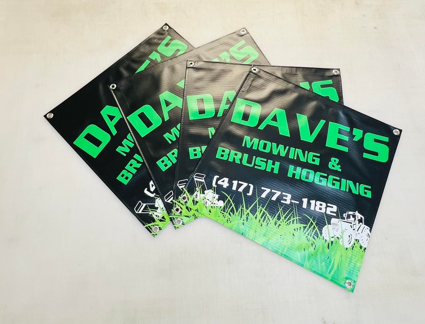 Stack of black business cards with green Dave’s logo and phone number, for roofing and bush hogging.