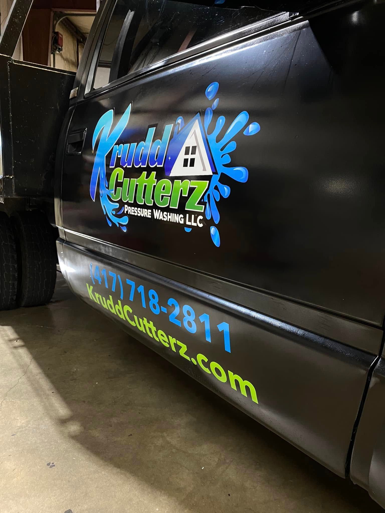 Black truck door with colorful Gatorz logo, phone number, and website branding on a glossy panel