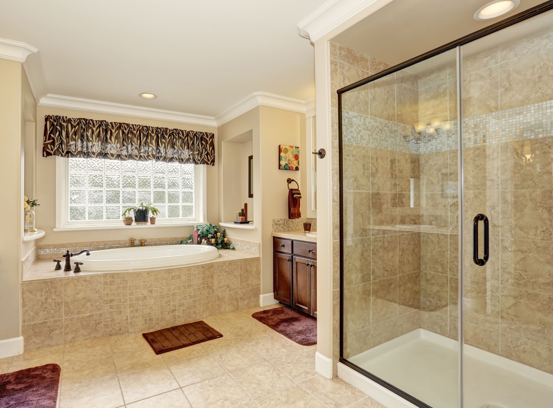 Bright bathroom with a glass shower, soaking tub, and tiled floor under a window