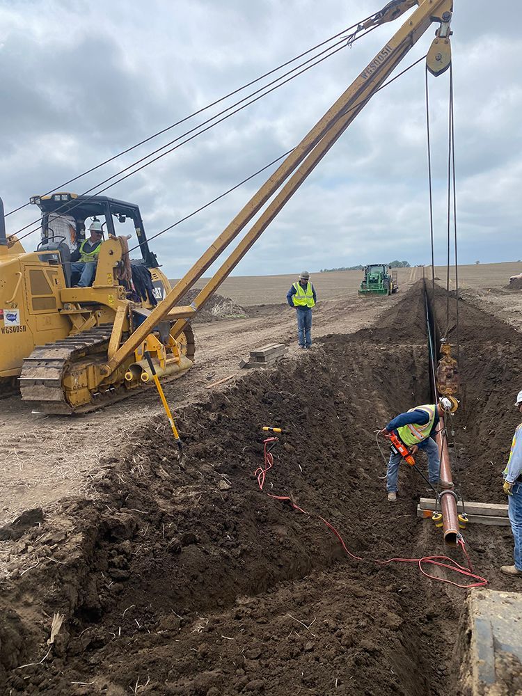 A group of construction workers are working on a pipe