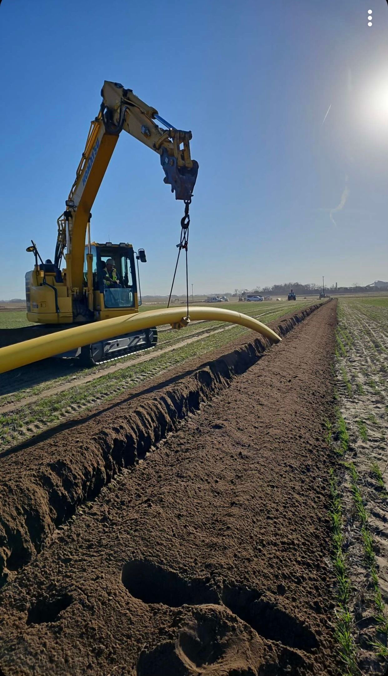 A yellow excavator is digging a hole in the ground
