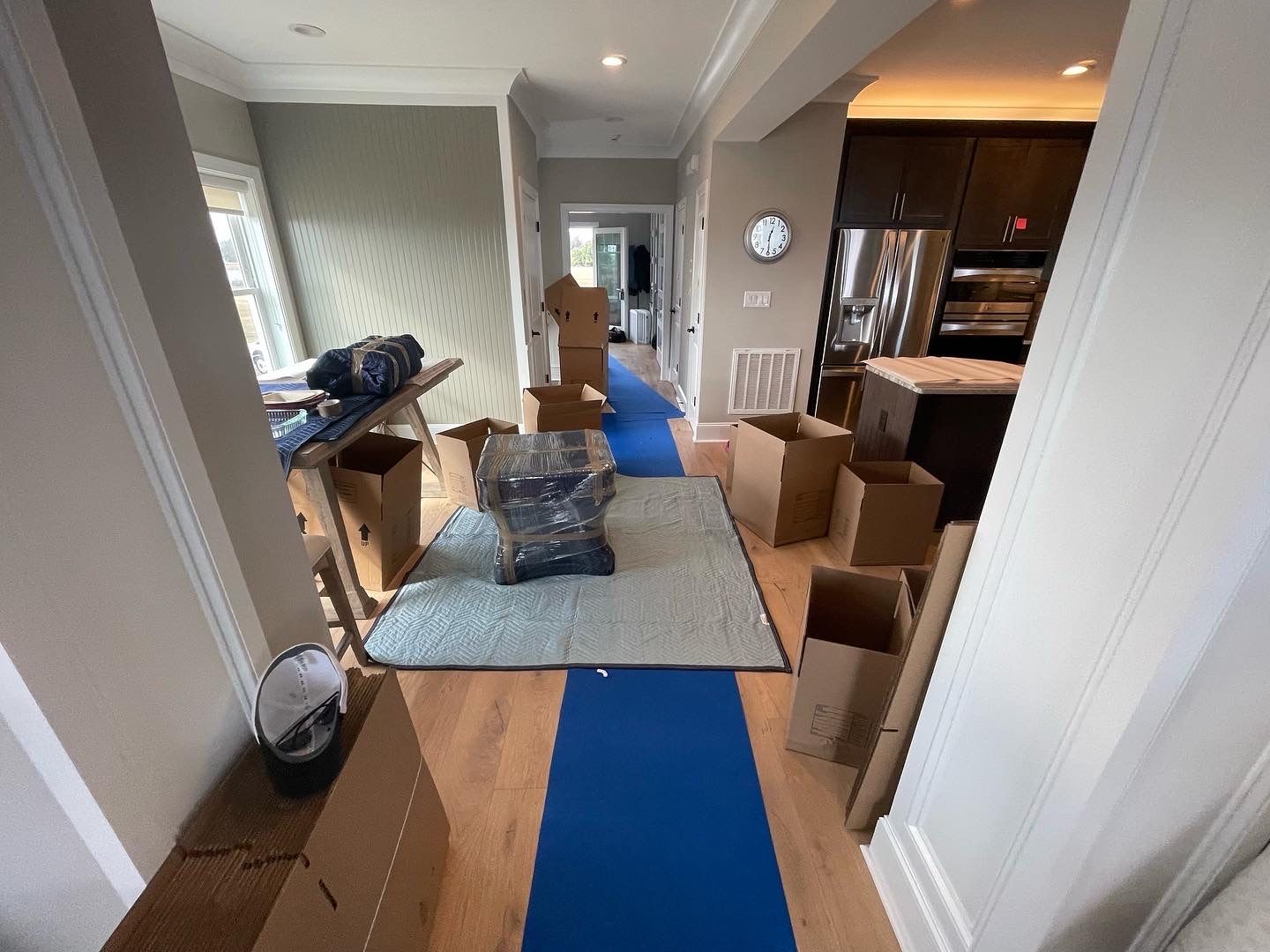 Two men are standing on a trailer filled with boxes.